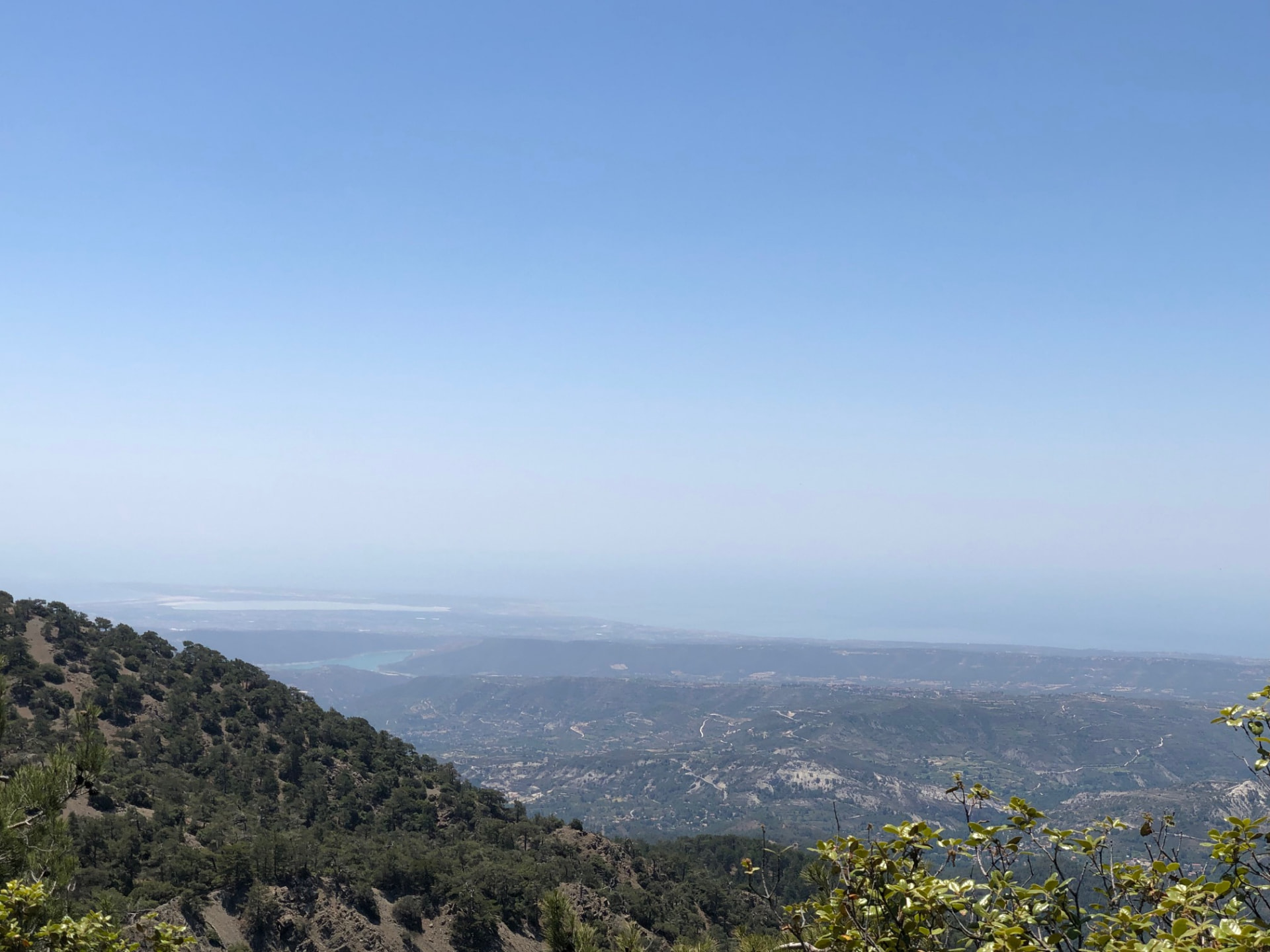 Wide view from the mountain down over hills toward the hazy coast