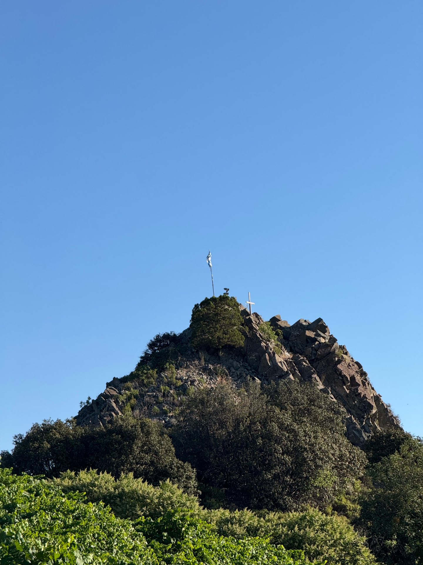 A rocky summit against a clear blue sky