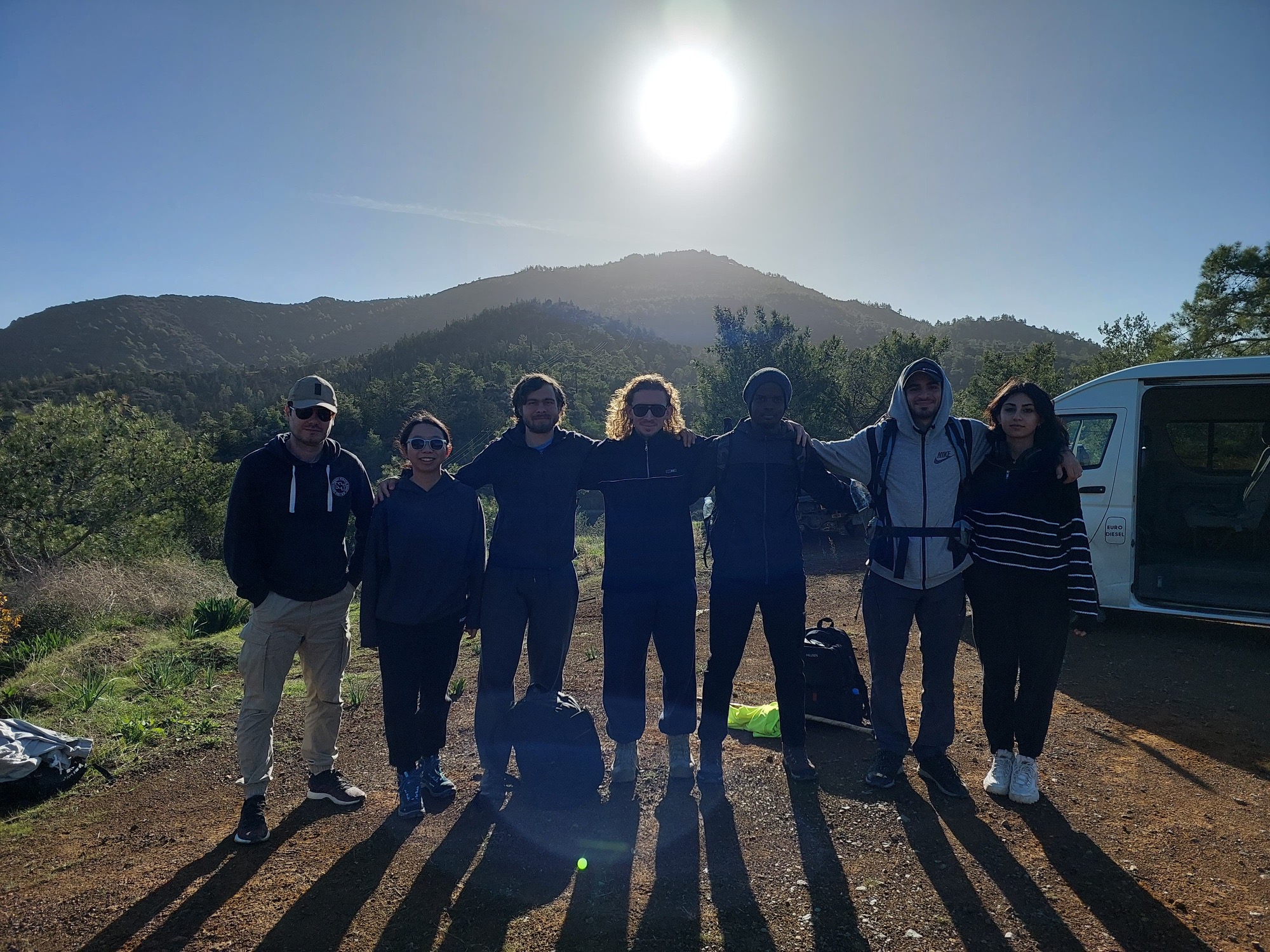 Seven hikers at the finish of the Stavrovouni trail with the mountain behind them