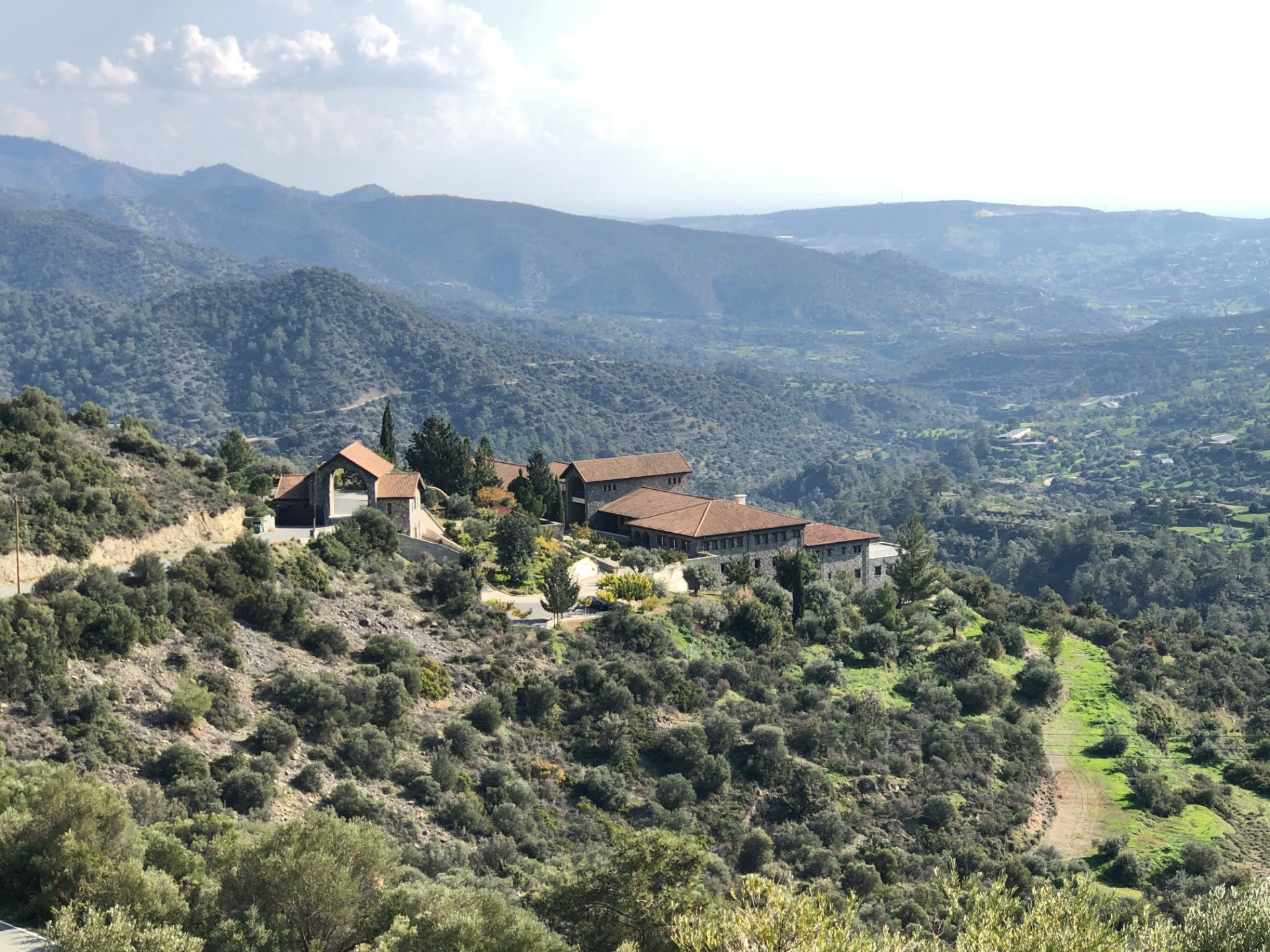 Panagia Amirous Monastery perched on a green hillside above the valley