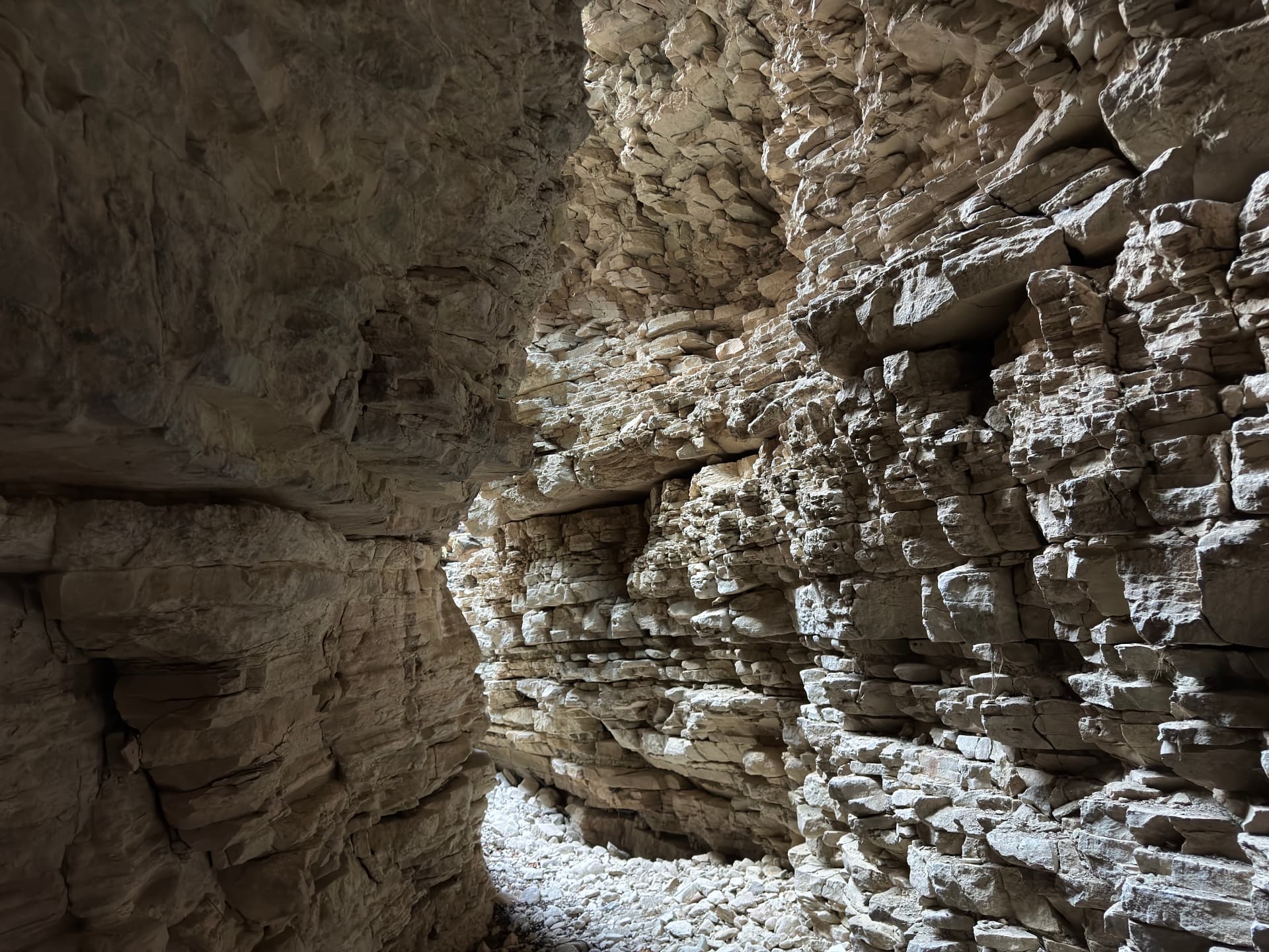 The dark, narrow heart of Klimadia Gorge, walls leaning in over a pebble floor