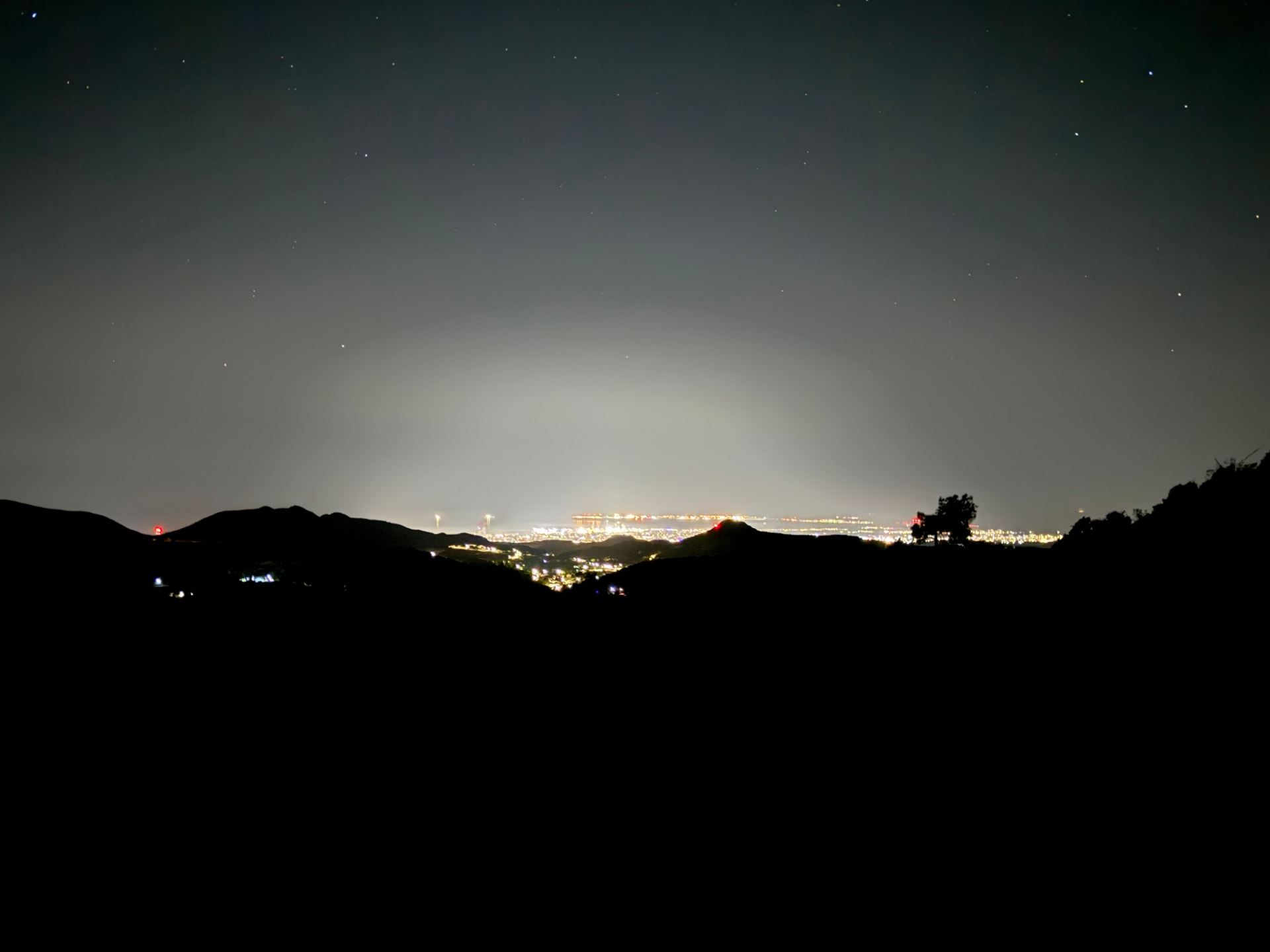 Distant lights beyond dark hills