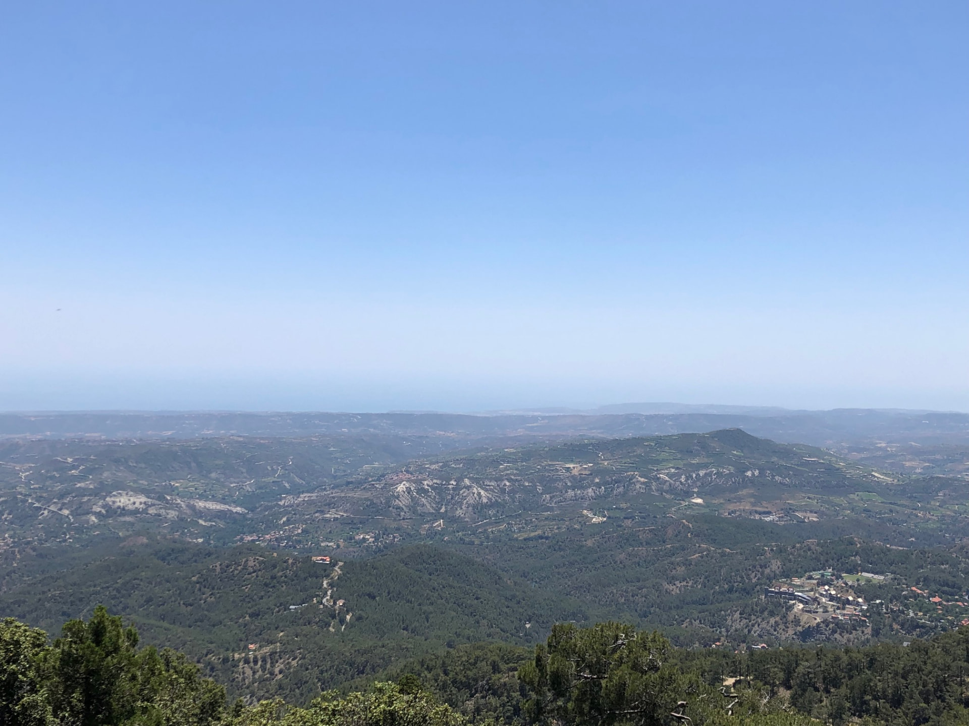 View over rolling hills and villages toward the distant sea