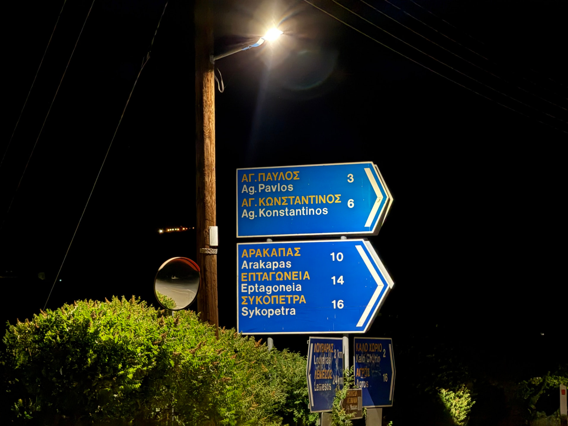 Road signs beneath a streetlight