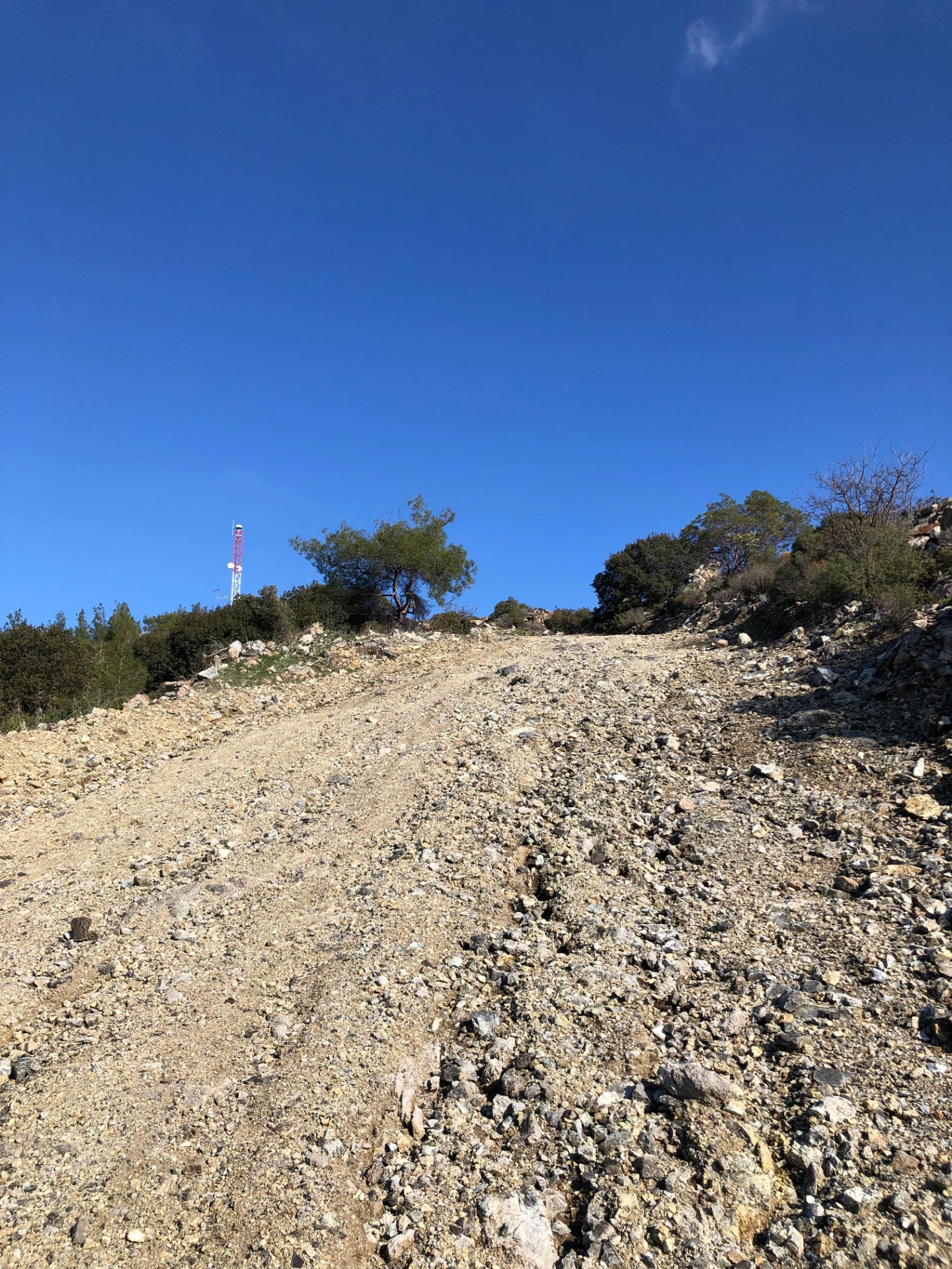 Steep loose gravel track climbing toward the antenna on the ridgeline